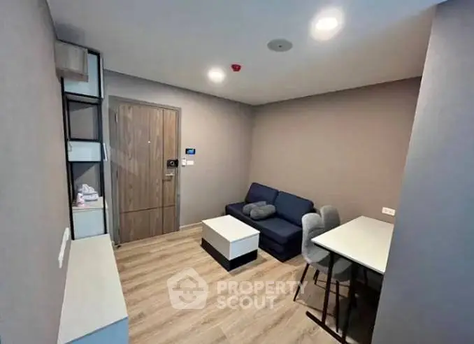 Modern living room with cozy seating and dining area, featuring sleek design and warm lighting.