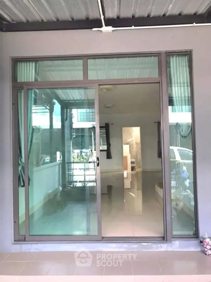 Modern glass sliding door entrance with sleek design and spacious interior view.