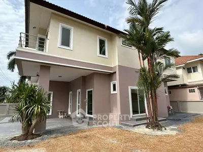 Modern two-story house with balcony and tropical landscaping