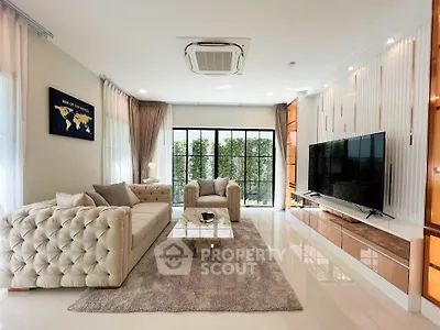 Luxurious living room with plush sofas, large TV, and elegant decor, perfect for relaxation and entertainment.