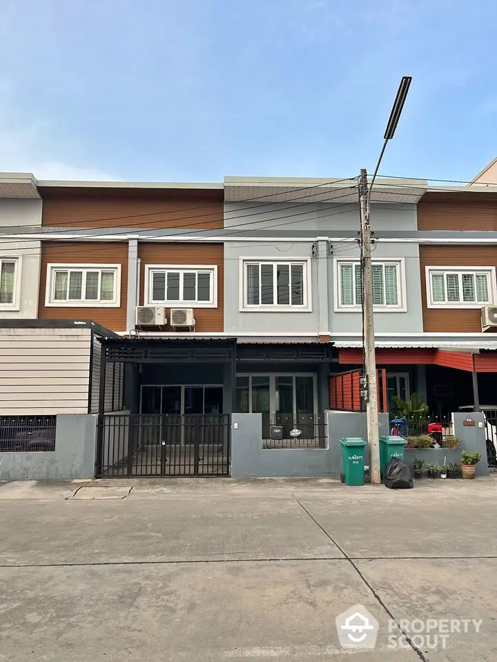 Modern townhouse exterior with clean lines and contemporary design in a suburban neighborhood.