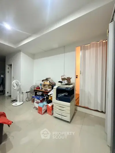 Spacious storage area with modern tile flooring and ample lighting, ideal for organizing household items.