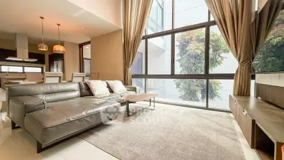 Luxurious living room with modern leather sofa and large windows offering natural light.