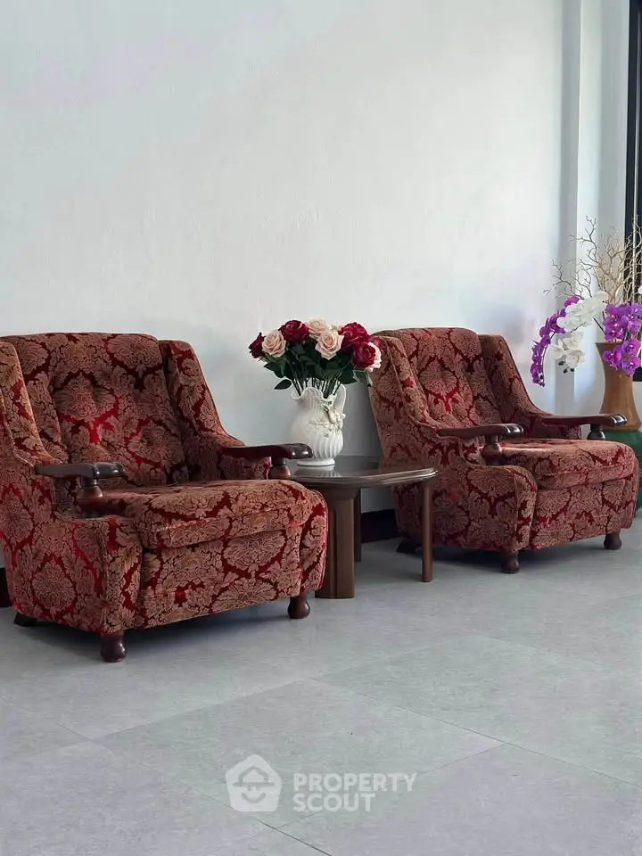 Elegant living room with vintage armchairs and floral decor, perfect for cozy relaxation.