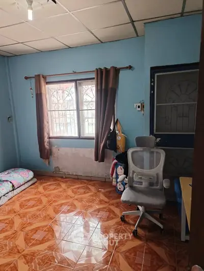 Cozy study room with chair and window, ideal for work or relaxation.