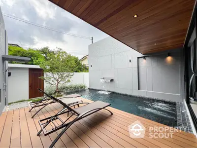 Luxurious modern poolside with sleek loungers and elegant water feature.