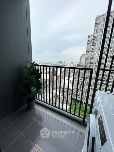 Modern balcony with city view and potted plant, perfect for urban living.