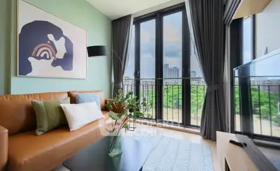 Modern living room with large windows and city view, stylish decor and comfortable seating.
