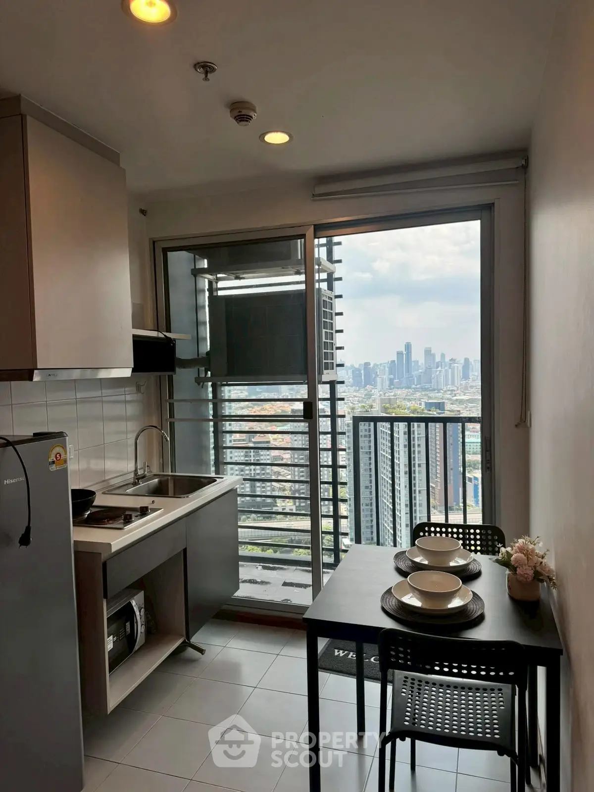 Modern kitchen with city view from balcony in high-rise apartment