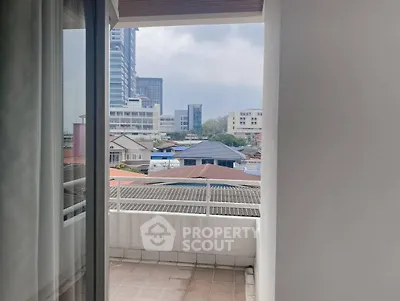 Spacious balcony with city view in modern apartment building.