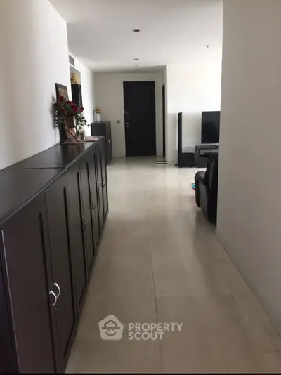 Spacious hallway leading to a modern living area with sleek furniture and decor.