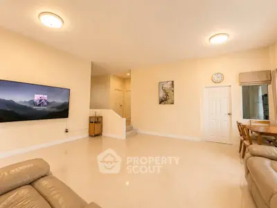 Spacious living room with modern decor and wall-mounted TV, perfect for family gatherings.