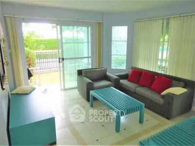 Bright living room with modern furniture and large windows overlooking garden