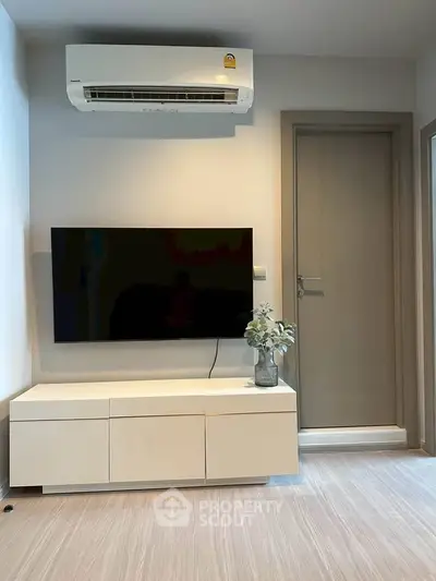 Modern living room with sleek TV setup and air conditioning unit