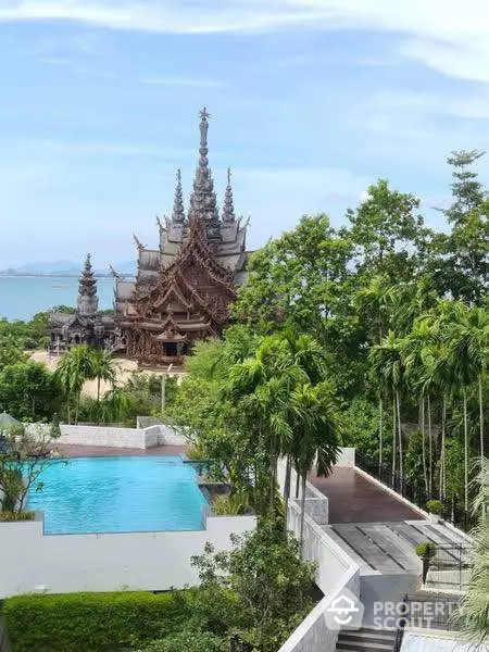 Stunning view of a unique architectural building with lush greenery and a serene pool.