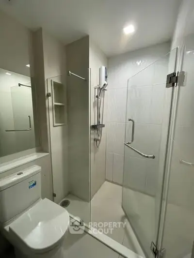 Modern bathroom with glass shower enclosure and sleek fixtures
