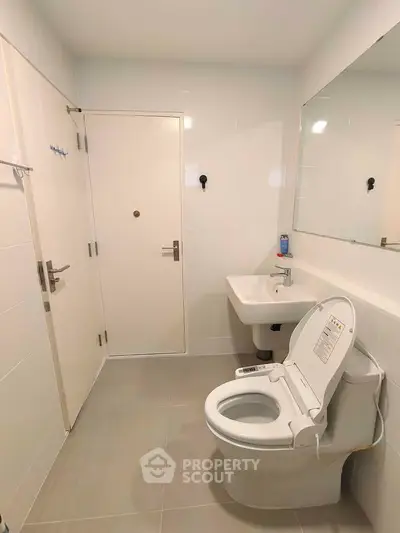 Modern bathroom with sleek fixtures and smart toilet in a contemporary home.