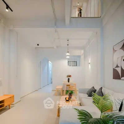 Modern living room with minimalist decor and open layout, featuring stylish furniture and contemporary artwork.