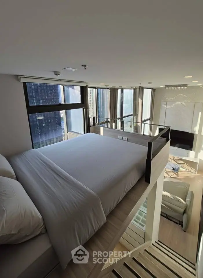 Modern loft bedroom with panoramic city views and stylish interior design.