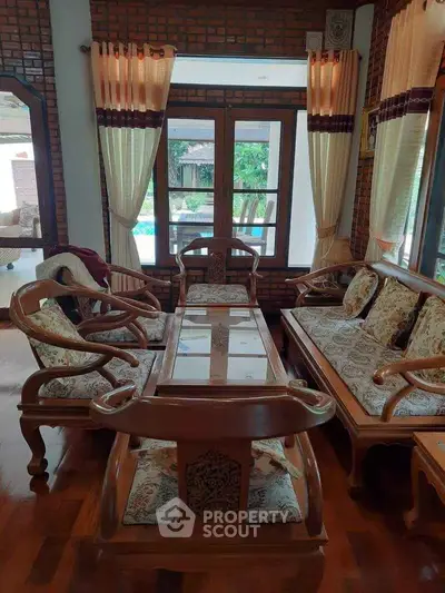 Charming living room with elegant wooden furniture and garden view, perfect for relaxation and entertaining.