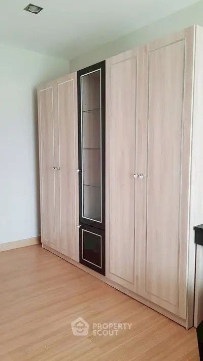 Spacious bedroom with elegant wooden wardrobe and sleek flooring