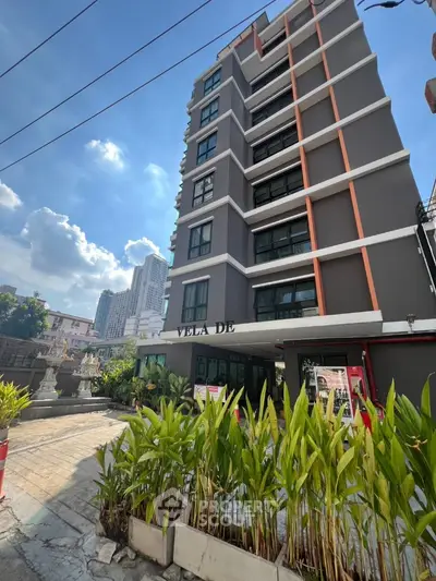 Modern urban apartment building with lush greenery and city skyline view