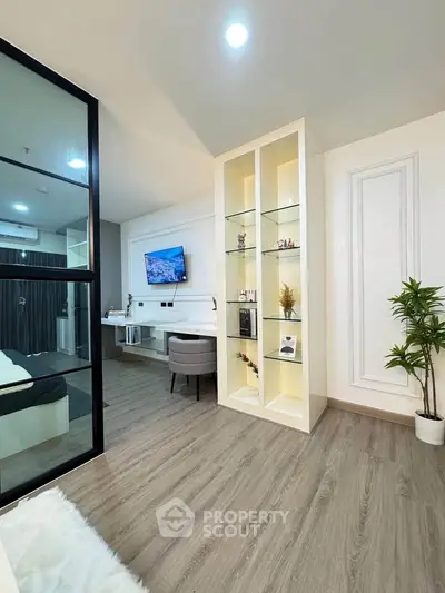 Modern living room with stylish decor and open layout, featuring a cozy workspace and elegant shelving.