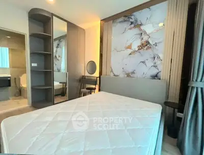 Modern bedroom with stylish marble accent wall and cozy furnishings