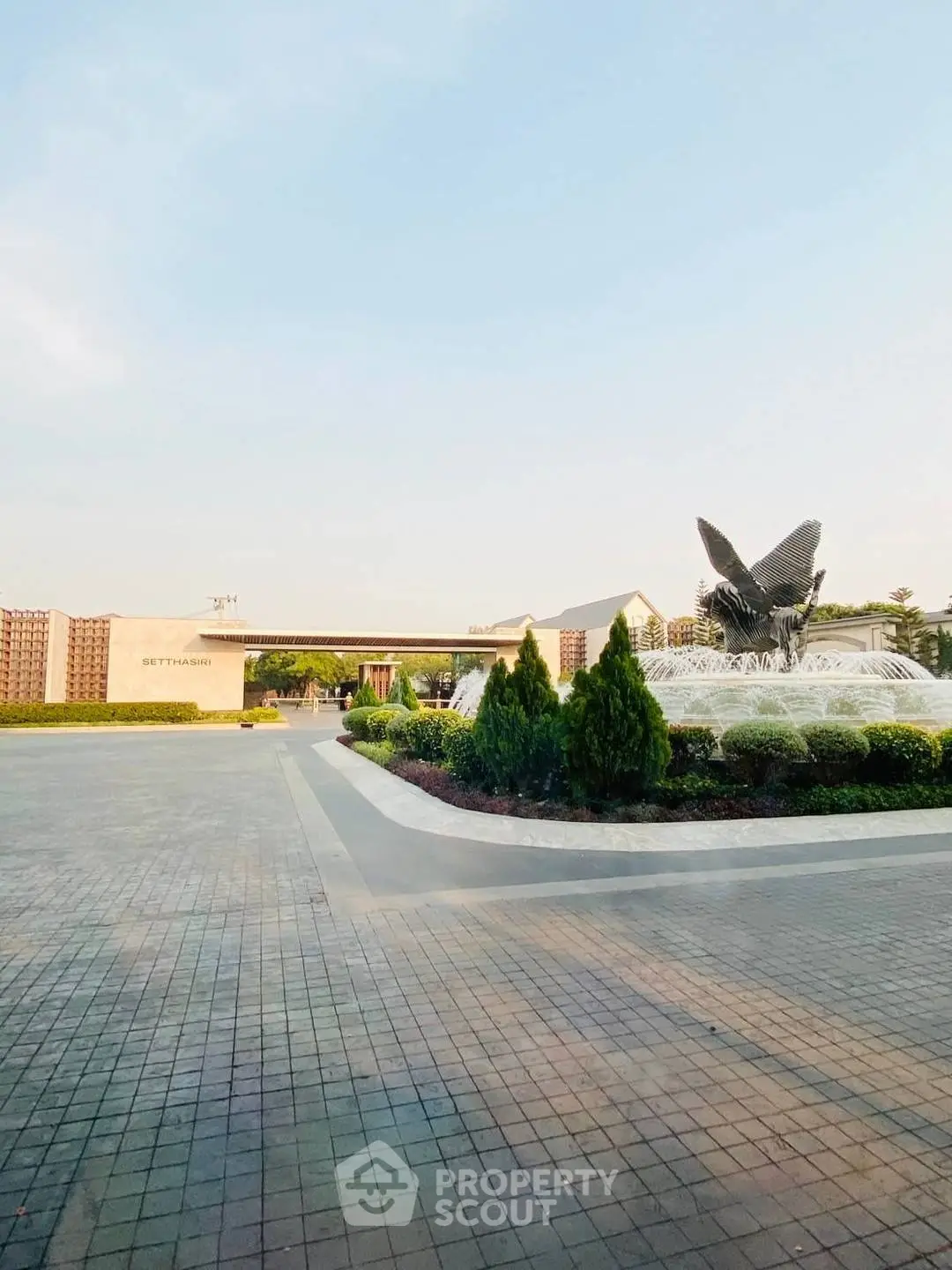 Elegant entrance with a stunning fountain and lush landscaping, perfect for luxury real estate.