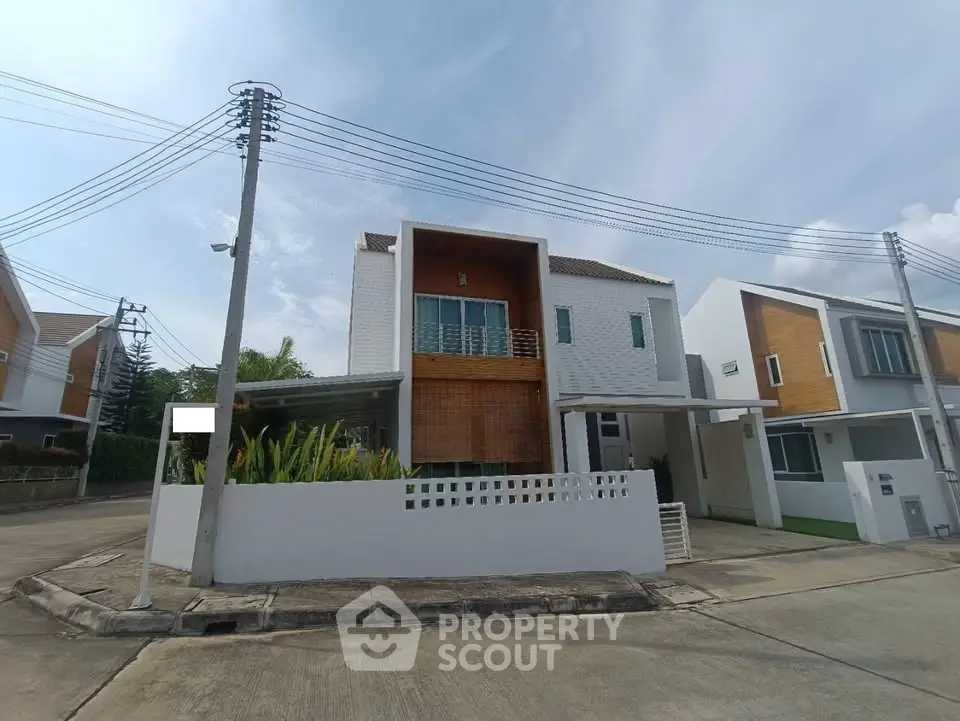 Modern two-story house with unique facade and spacious driveway on a sunny day.