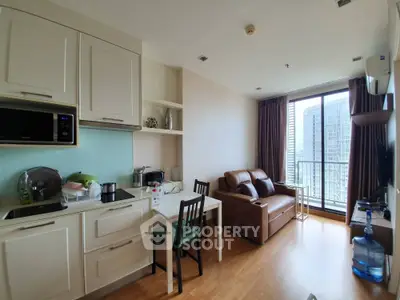 Modern apartment interior with open kitchen and cozy living area, featuring a balcony with city view.