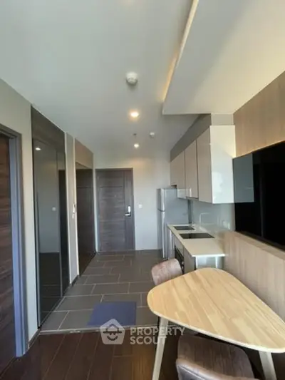Modern kitchen with sleek cabinetry and dining area in contemporary apartment