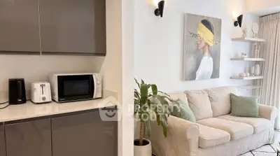 Stylish modern living room with cozy sofa and sleek kitchen appliances