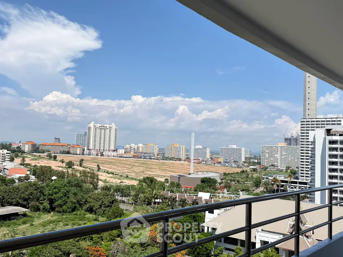 Stunning cityscape view from a modern balcony, showcasing urban skyline and lush greenery.