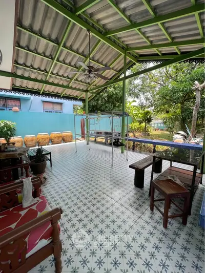 Charming covered patio with tiled floor and garden view, perfect for relaxation.