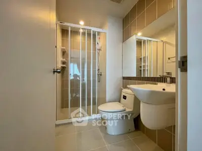 Modern bathroom with sleek fixtures and spacious shower in contemporary apartment.