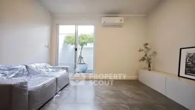 Modern living room with sleek tile flooring and large window view.