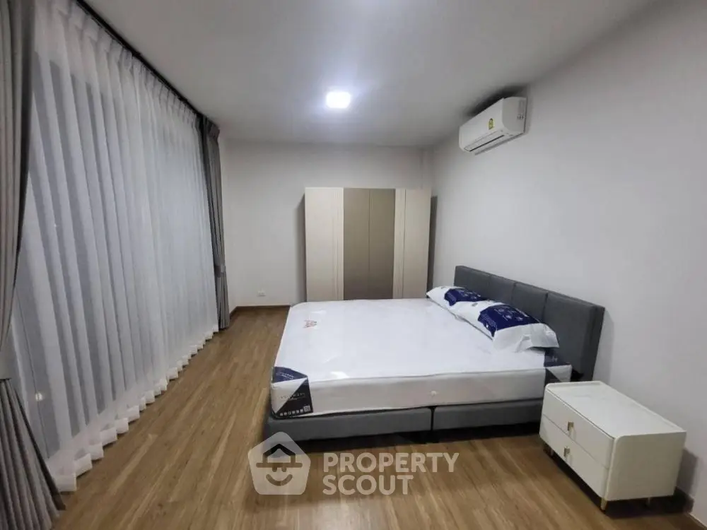 Spacious bedroom with modern design and large windows for natural light.