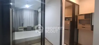 Modern apartment interior with bedroom and kitchen view, featuring sleek design and ample storage.