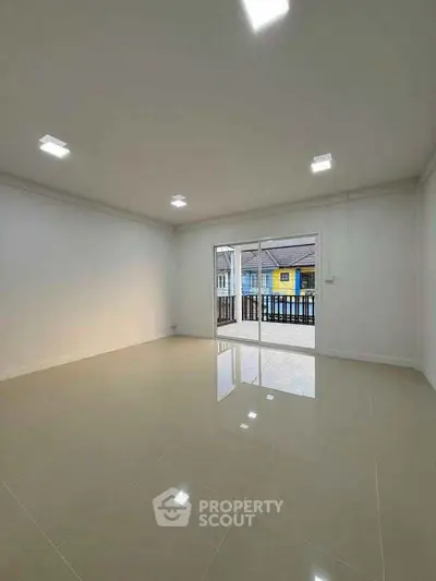 Spacious empty room with glossy tiled floors and balcony view, perfect for customization.