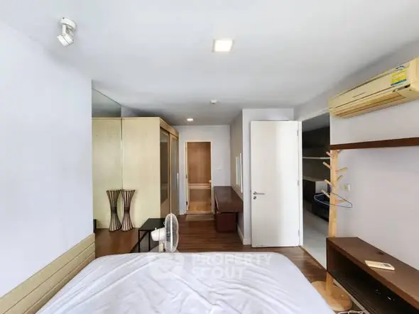Spacious bedroom with modern decor and air conditioning in a stylish apartment.