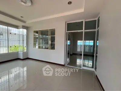 Spacious modern living room with large windows and sleek tile flooring