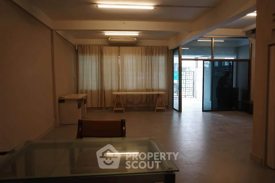 Spacious living room with large windows and glass table, ideal for modern living.