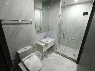 Modern bathroom with sleek design featuring glass shower and elegant fixtures.
