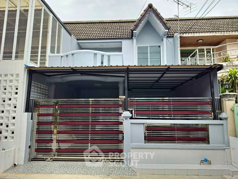 Charming townhouse with modern facade and secure gated entrance in a serene neighborhood.