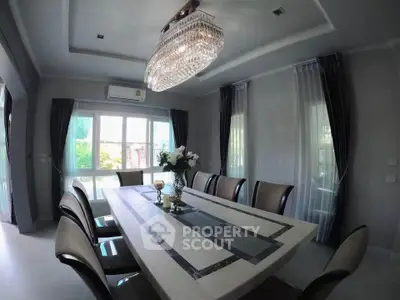 Elegant dining room with luxurious chandelier and large windows, perfect for entertaining guests.