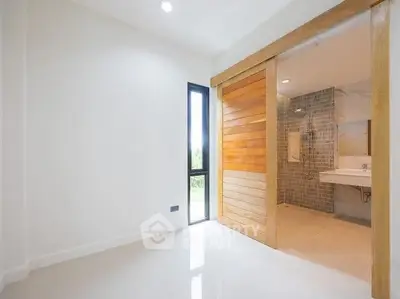 Spacious modern bathroom with wooden sliding door and elegant tile design.