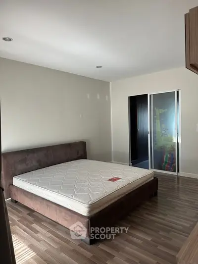 Spacious bedroom with modern bed and sliding closet doors, perfect for relaxation.