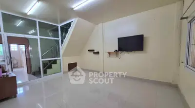 Spacious living room with modern TV setup and sleek tiled flooring