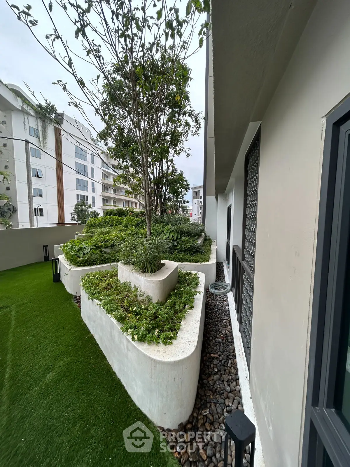 Modern garden area with lush greenery and contemporary design in urban setting.